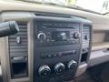 The dashboard of a 2012 RAM 2500 featuring a radio display climate control knobs and various buttons