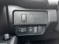 A close-up of the control panel in a 2022 Toyota Tacoma featuring buttons for door functions and power outlets