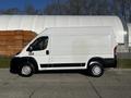 A white 2021 RAM Promaster van parked on the street showing its side profile with large wheels and a simple design