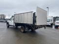 A white 2008 Dodge Ram 5500 with a flatbed and silver cargo sides viewed from the rear angle