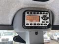 A digital radio display showing frequency 93.7 with buttons for volume and tuning in a vehicle interior