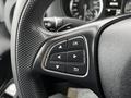 Close-up of a steering wheel control panel featuring buttons for navigation and settings on a Mercedes-Benz Metris