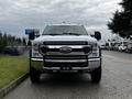 A white 2021 Ford F-550 positioned head-on showcasing its front grille and large headlights