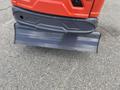 A close-up view of the rear blade of a 2024 AGT Mini Excavator featuring a gray metal surface with a slightly curved edge