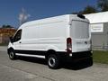 A 2022 Ford Transit van in white with a black bottom trim parked on a paved surface showcasing its side profile and rear view