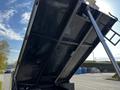 A 2021 Ford F-550 with a raised dump bed showing the underside structure and hydraulic lift system