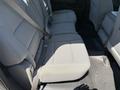 The interior of a 2016 GMC Sierra 1500 showing the backseat with gray fabric upholstery and seat belts