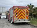 A 2007 Ford F-550 fire truck with red and yellow chevron markings on the rear and emergency lights
