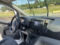 Interior view of a 2019 Nissan NV200 showcasing the dashboard steering wheel gear shifter and control knobs