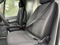 Interior view of a 2016 Mercedes-Benz Sprinter showing two black fabric seats with seatbelts and a steering wheel