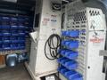 Interior of a 2010 Ford Econoline showing storage units with blue bins and a mechanical control panel