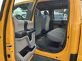 A yellow 2017 Ford F-250 SD with an open passenger door revealing a spacious interior and gray seating in the back