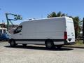 A white 2019 Mercedes-Benz Sprinter van parked on a lot with a smooth exterior and large windows