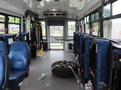 Interior of a 2020 Chevrolet Express with blue seats and an exposed tire secured with straps in the middle of the floor