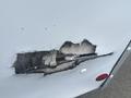 A damaged section of a 2004 Ford Econoline showing exposed wood and cracks in the exterior surface
