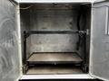 A 2016 Ford F-550 with an open truck bed showing a black metal frame and a flat surface inside the cargo area