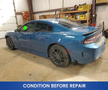 2022 Dodge Charger in blue with tinted windows and aftermarket wheels parked in a garage showing signs of wear and needing repairs