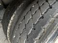 Close-up of a worn tire on a tandem dump trailer showing significant tread wear and cracks on the surface