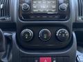The dashboard controls of a 2016 RAM Promaster featuring climate control dials and a radio display with buttons for tuning and media settings