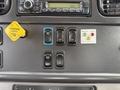 Dashboard controls of a 2016 Freightliner 108SD featuring buttons for light test and options along with a parking brake lever and warning indicators