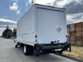 A white 2006 Hino 268 box truck with a blank rear door and a diamond-shaped emblem on the side