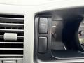 A close-up view of the dashboard of a 2009 Toyota Hiace featuring a button labeled ROOM and various gauges including a temperature gauge