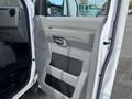Interior door panel of a 2009 Ford Econoline featuring a gray armrest speaker grille and door handle