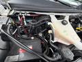 The image shows the engine compartment of a 2017 Chevrolet Express with various components including the battery and fluid reservoirs visible among wiring and hoses