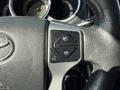 Close-up of the steering wheel of a 2015 Toyota Tacoma featuring controls for phone connectivity and vehicle settings