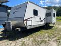 A 2014 Starcraft Launch 24RLS travel trailer with a silver exterior and a slide-out section on the side