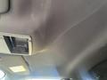 The interior ceiling of a 2014 Ford F-150 showing a fabric headliner and a sun visor attachment without any visible features or items