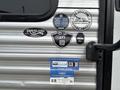 A 2021 Jayco Jay Flight travel trailer featuring various stickers and labels indicating specifications and affiliations
