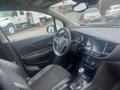 Interior view of a 2018 Buick Encore featuring a steering wheel with controls a sleek dashboard and a gear shifter on the center console