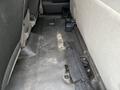 Interior view of a 2010 Ford F-150 with a carpeted floor showing visible dirt and debris