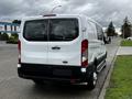 A white 2023 Ford Transit van seen from the rear with large back doors and a high roof design