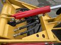 A close-up view of the hydraulic system on a 2024 AGT Industrial KRW23 Mini Loader featuring red hydraulic hoses and a yellow metal frame