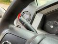 Close-up of the steering wheel and dashboard controls of a 2013 Ford F-550 showing the turn signal stalk and speedometer