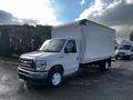 A 2021 Ford Econoline box truck with a white cargo area and a gray front cab parked on the street