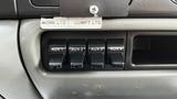 Control panel of a 2007 Ford F-550 with four toggle switches labeled AUX 1 AUX 2 AUX 3 and AUX 4