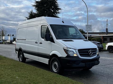 A 2017 Mercedes-Benz Sprinter van with a white exterior and black accents parked on a street