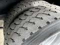 Close-up of the tires on a 2006 GMC C5000 showing worn tread patterns and slight debris embedded in the grooves
