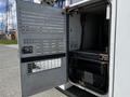 A 2008 Ford F-550 service vehicle with an open door revealing a storage compartment and equipment inside