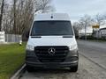 Front view of a 2022 Mercedes-Benz Sprinter with a prominent black grille featuring the Mercedes-Benz logo and a sleek silver body