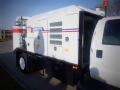 A 2007 Ford F-650 work truck featuring a large white and black exhaust system with red and blue stripes along its side