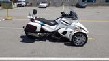 A white 2013 Can-Am Spyder three-wheeled motorcycle with a sporty design featuring a large windshield and silver alloy wheels