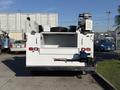 A 2009 Ford F-550 service vehicle with a white exterior featuring an open rear compartment and mounted equipment on the roof