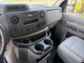 Interior view of a 2023 Ford E-450 showing the dashboard with radio controls air conditioning knobs and a center console with cup holders