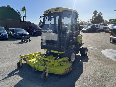 A 2010 Kubota F3990 lawn mower with a glass cab and a large cutting deck in the front, painted in bright yellow and green colors