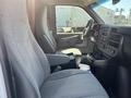 Interior view of a 2012 Chevrolet Express showing the driver's seat and dashboard with controls and cup holders