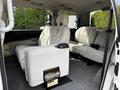 Interior of a 2003 Mitsubishi 7 Passenger Van featuring two front seats and a rear bench seat with grey upholstery and seatbelts